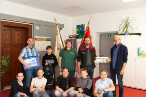 Erwachsene und Kinder von NSG-Verwaltung und Gymnasium präsentieren stolz die Auszeichnung "Wildnis-Schule"